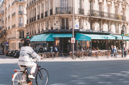 a man riding a bike down a street next to tall buildings