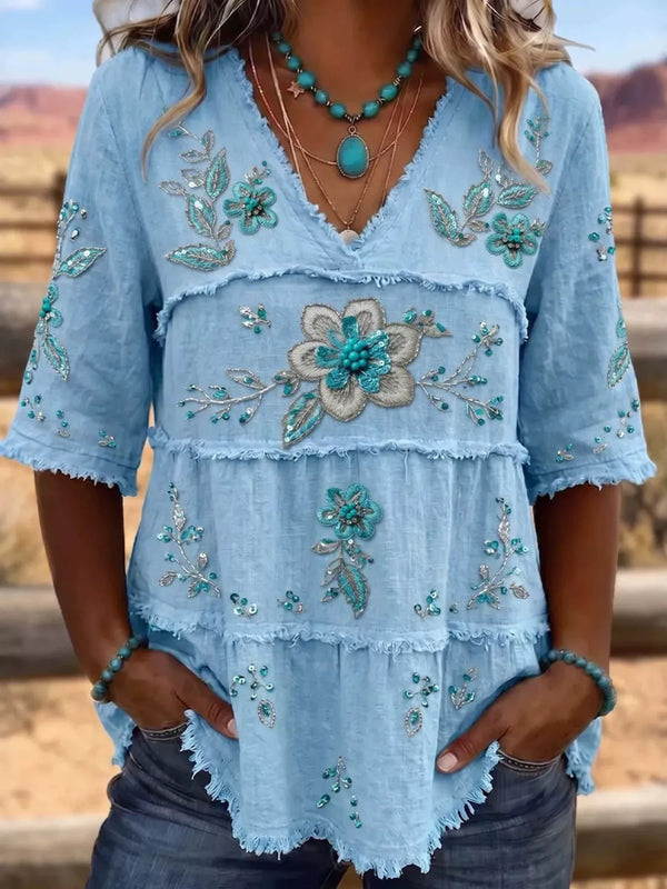 Blouse col V étagée broderies florales sequins ourlets effilochés